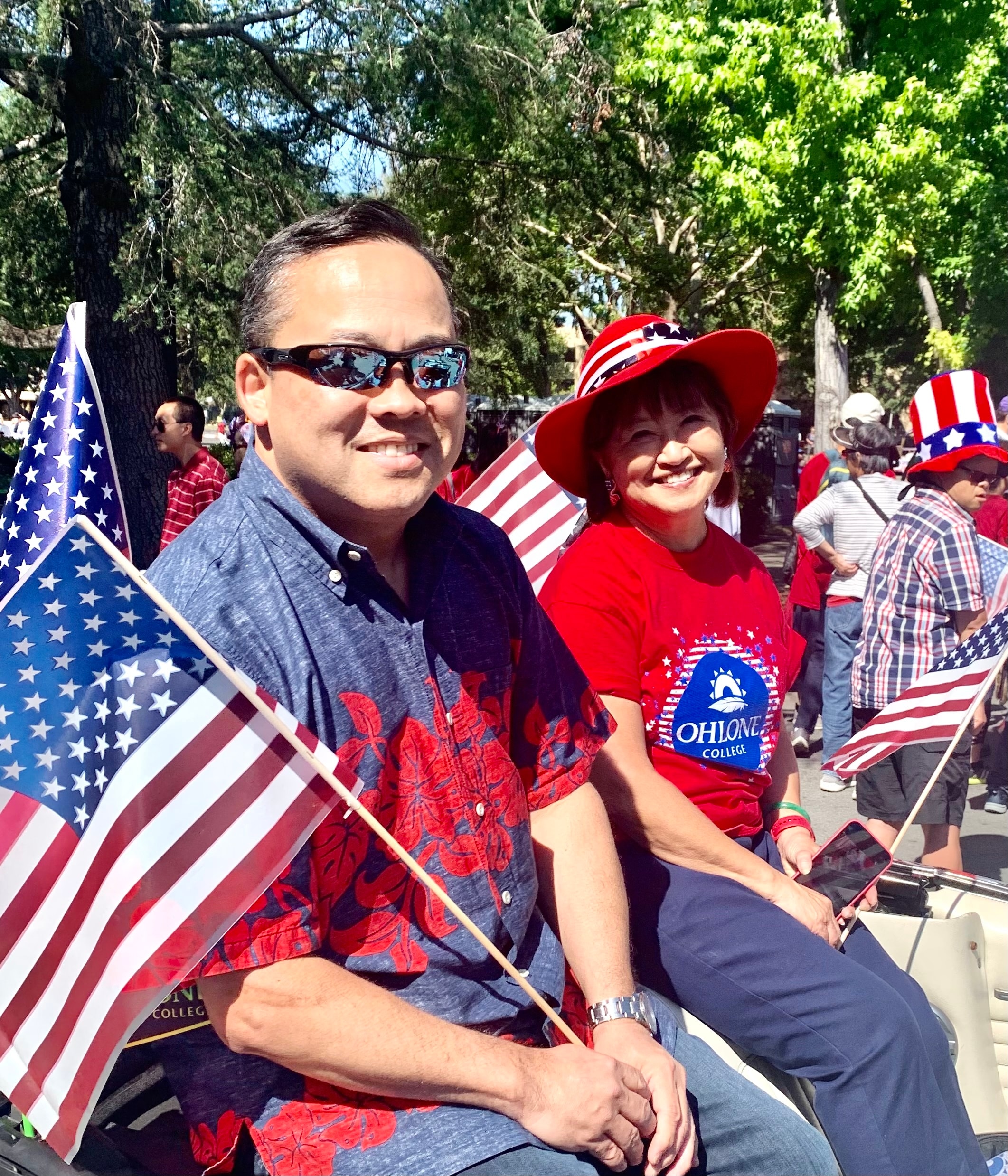 Couple holding American flags at parade